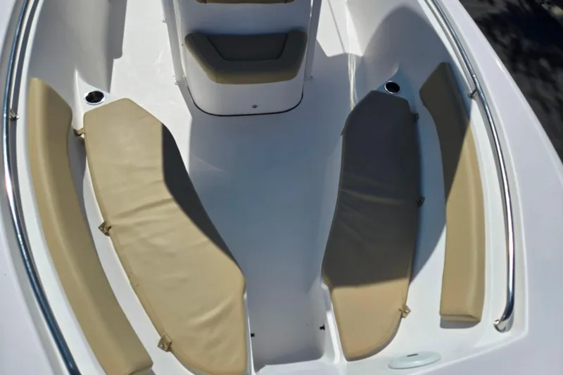 Slide: The Image of 2016 Tidewater 220 LXF boat interior with beige cushioned seating and sleek white design. - 17