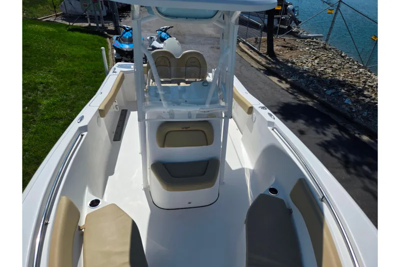 Slide: The Image of 2016 Tidewater 220 LXF boat interior with seating and console, docked near water. - 18