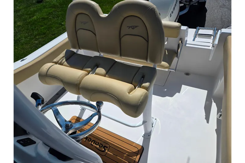 Slide: The Image of 2016 Tidewater 220 LXF boat interior with beige seating and steering wheel. - 20