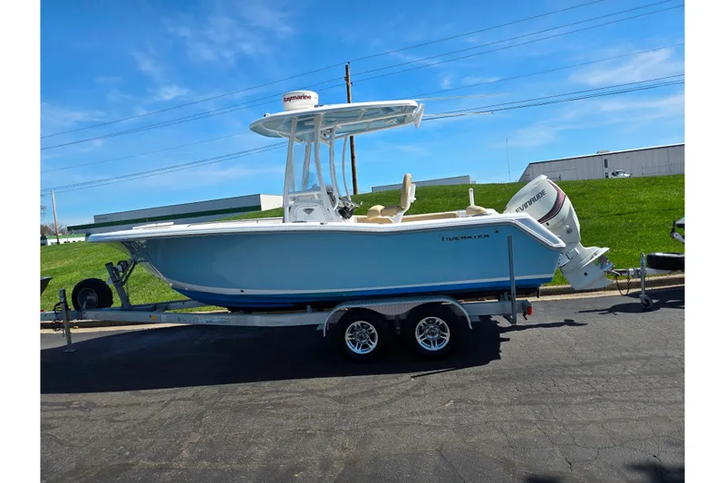 Slide: The Image of 2016 Tidewater 220 LXF boat on trailer, parked outdoors under clear blue sky. - 4