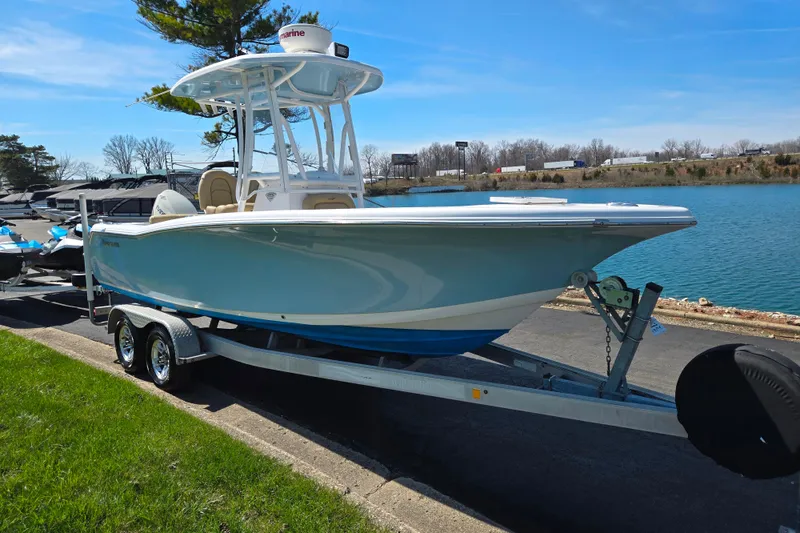 Slide: The Image of 2016 Tidewater 220 LXF boat on trailer by a lake, under clear blue sky. - 8
