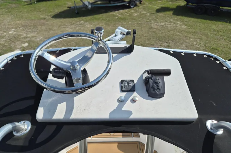 Slide: The Image of Steering console of a 2002 Mako 221 Center Console boat, featuring controls and steering wheel. - 14