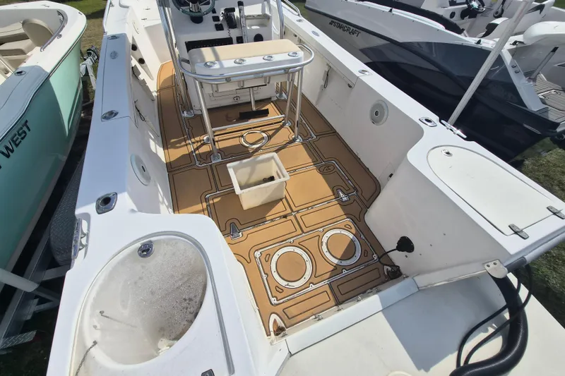 Slide: The Image of 2002 Mako 221 Center Console boat interior with tan deck and fishing equipment. - 4