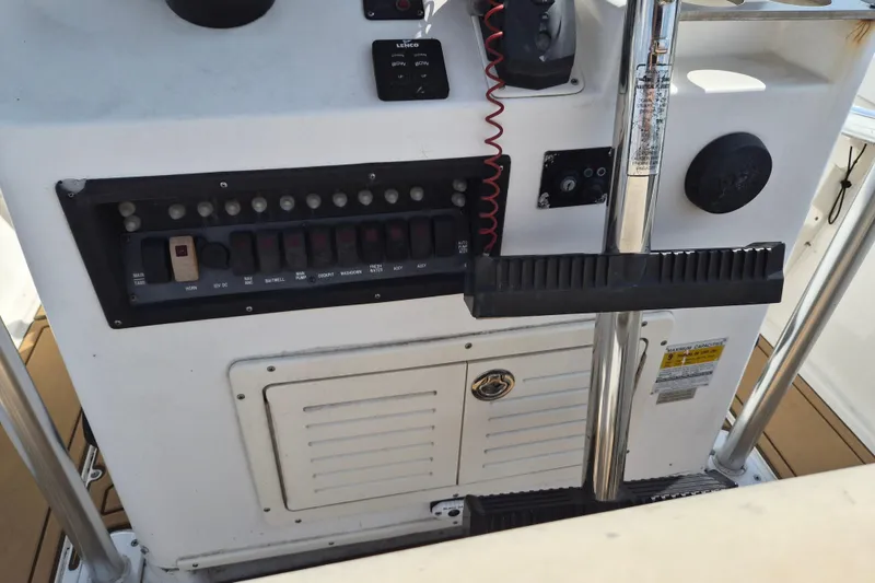Slide: The Image of Center console controls of a 2002 Mako 221 boat, featuring switches and gauges. - 6