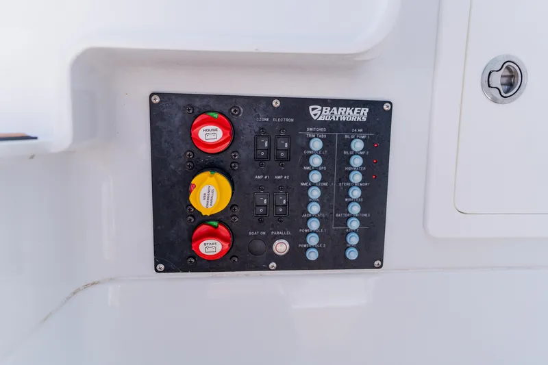 Slide: The Image of Control panel of a 2017 Barker Boatworks 26, featuring switches and battery controls. - 21