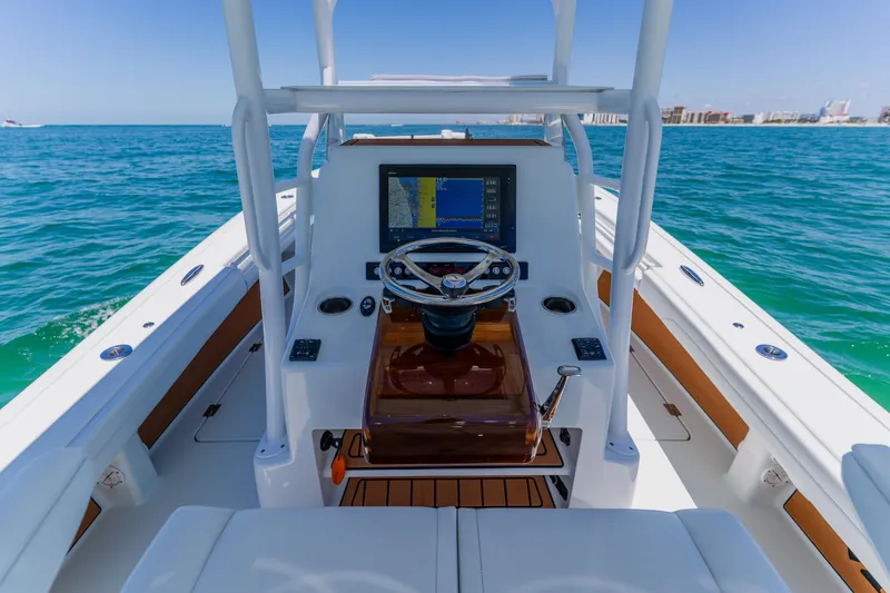 Slide: The Image of 2017 Barker Boatworks 26 helm with navigation display, steering wheel, and ocean view. - 29