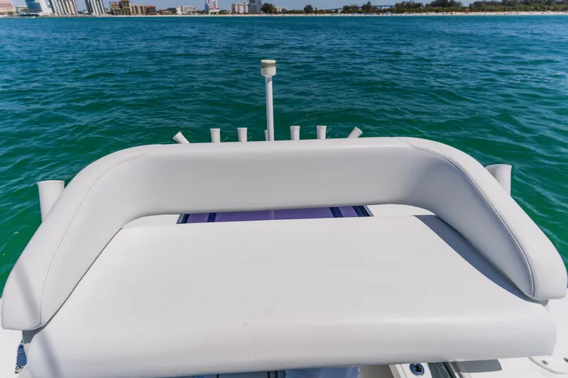 Slide: The Image of 2017 Barker Boatworks 26 with white seating, overlooking clear blue water and distant shoreline. - 35