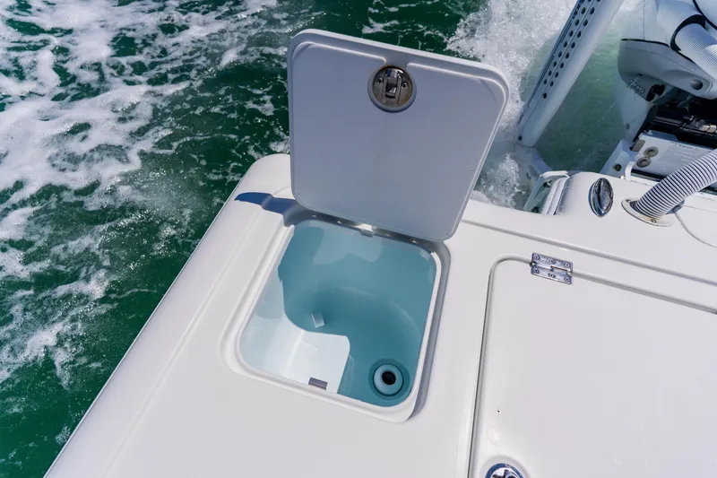 Slide: The Image of Open hatch on 2017 Barker Boatworks 26, revealing storage compartment, with ocean water in background. - 42