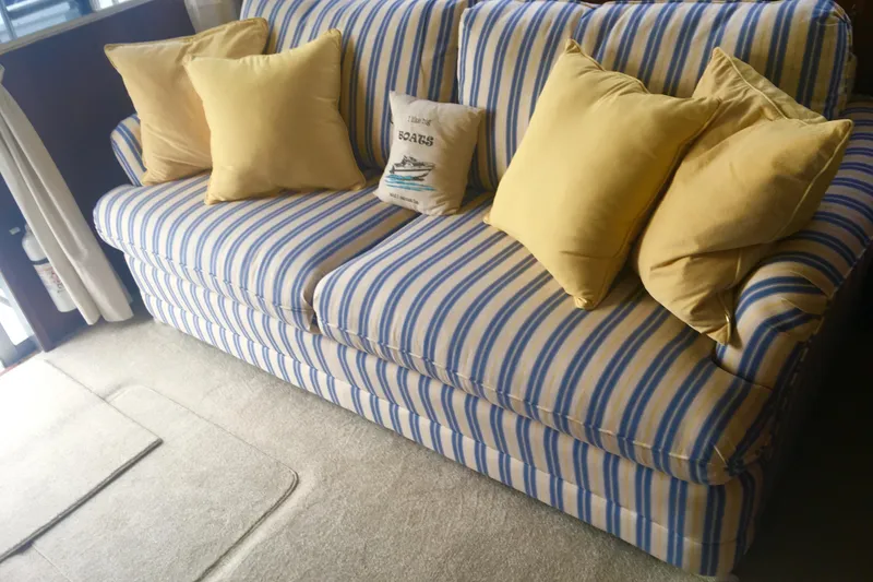 Slide: The Image of Striped sofa with yellow cushions inside a 1985 Bertram 33 Flybridge Cruiser. - 13