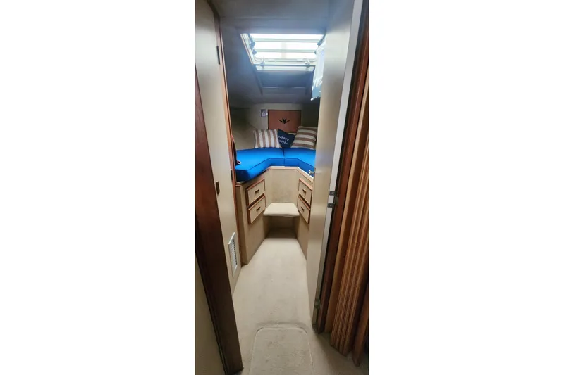 Slide: The Image of Interior cabin of 1985 Bertram 33 Flybridge Cruiser with skylight and blue bedding. - 15