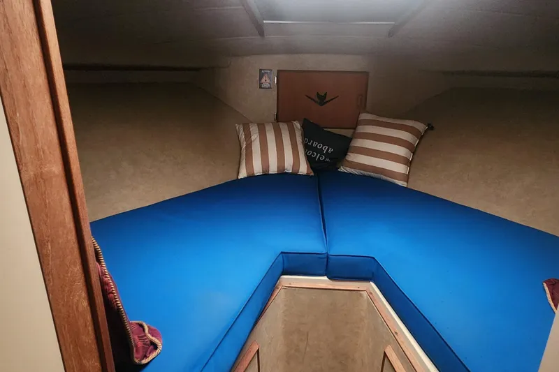 Slide: The Image of Interior cabin of 1985 Bertram 33 Flybridge Cruiser with blue cushions and striped pillows. - 16