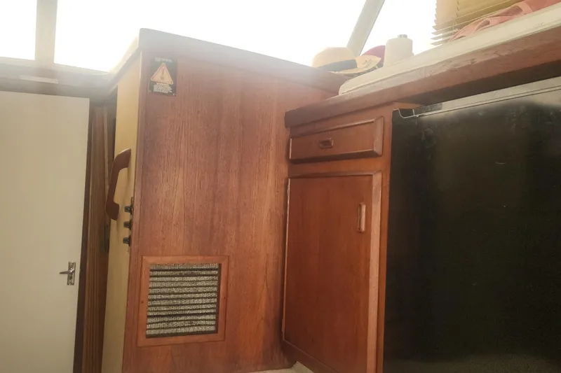 Slide: The Image of Interior of 1985 Bertram 33 Flybridge Cruiser with wooden cabinetry and natural lighting. - 18