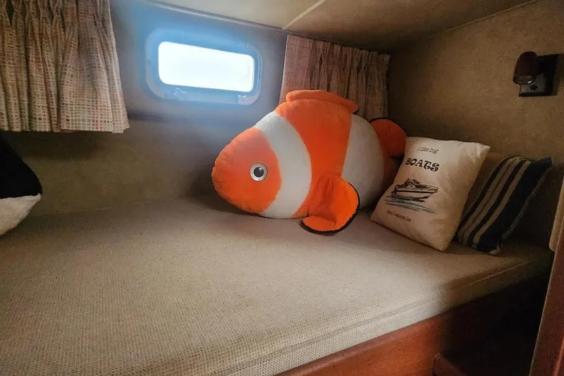 Slide: The Image of Cozy cabin bed in 1985 Bertram 33 Flybridge Cruiser with plush fish toy and nautical pillow. - 21