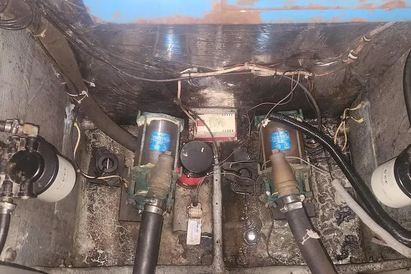 Slide: The Image of Engine compartment of a 1985 Bertram 33 Flybridge Cruiser with visible pumps and wiring. - 24