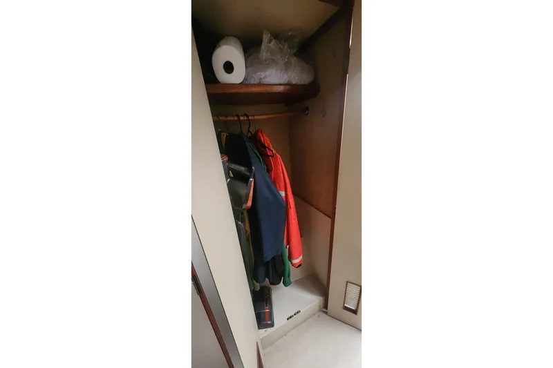 Slide: The Image of Closet interior on 1985 Bertram 33 Flybridge Cruiser with hanging clothes and shelf storage. - 27