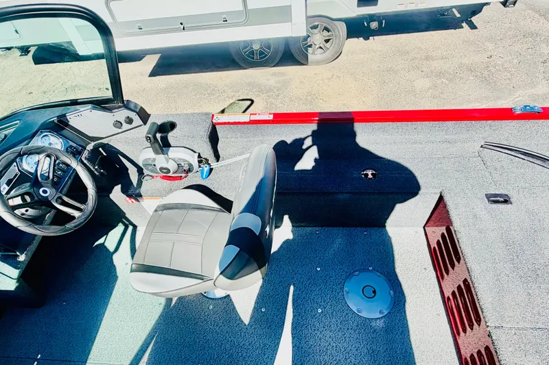 Slide: The Image of 2026 Lund 1650 Angler Sport boat interior with steering wheel and seating. - 13