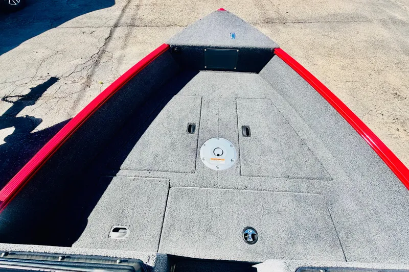 Slide: The Image of 2026 Lund 1650 Angler Sport boat deck with red trim, featuring storage compartments. - 16