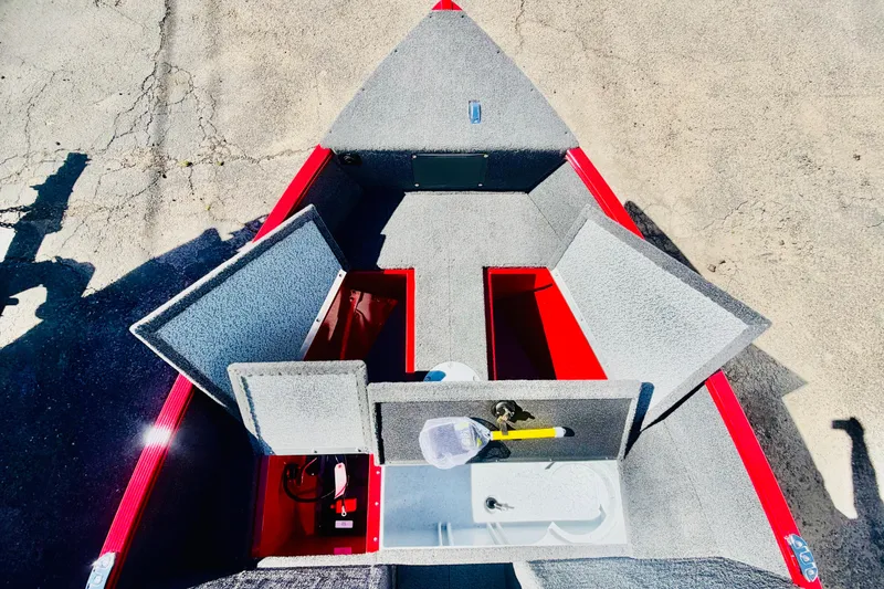 Slide: The Image of 2026 Lund 1650 Angler Sport boat interior with open storage compartments and red accents. - 17