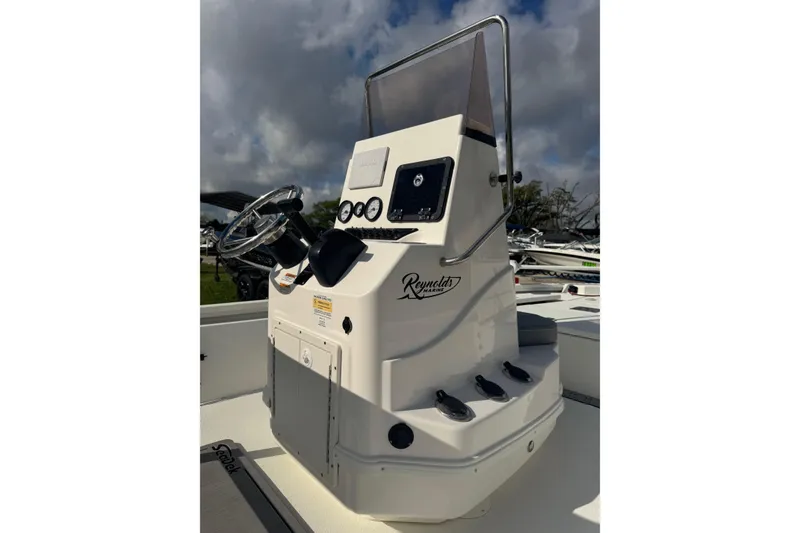 Slide: The Image of 2022 Avid 19 FS boat console with steering wheel and controls under cloudy sky. - 15