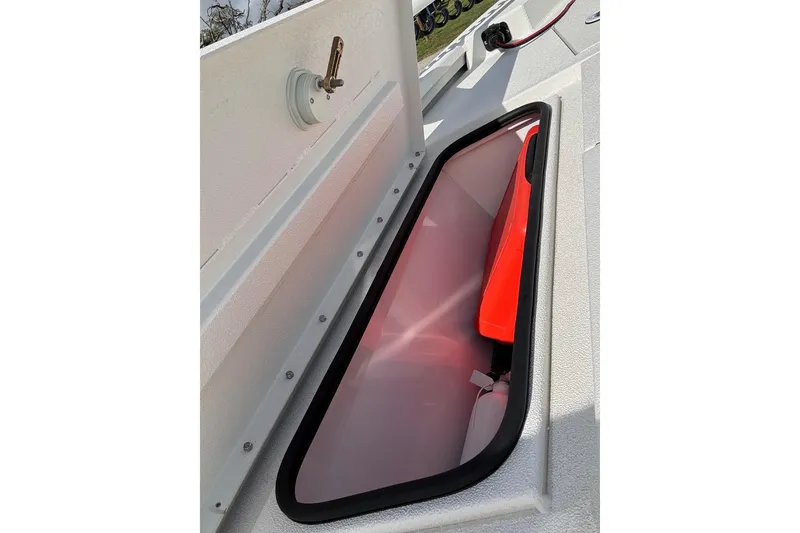 Slide: The Image of Storage compartment on a 2022 Avid 19 FS boat, featuring a red interior. - 17