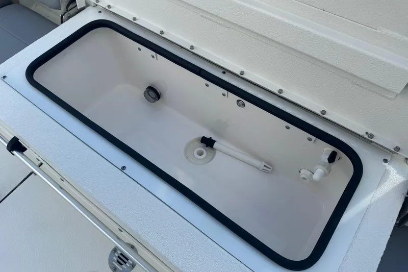 Slide: The Image of Open storage compartment in 2022 Avid 19 FS boat, featuring a clean, white interior. - 23