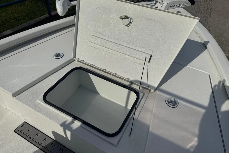 Slide: The Image of Open storage compartment on 2022 Avid 19 FS boat deck with ruler measurement. - 24