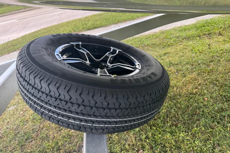 Slide: The Image of Spare tire mounted on a 2022 Avid 19 FS trailer, parked on grass. - 5