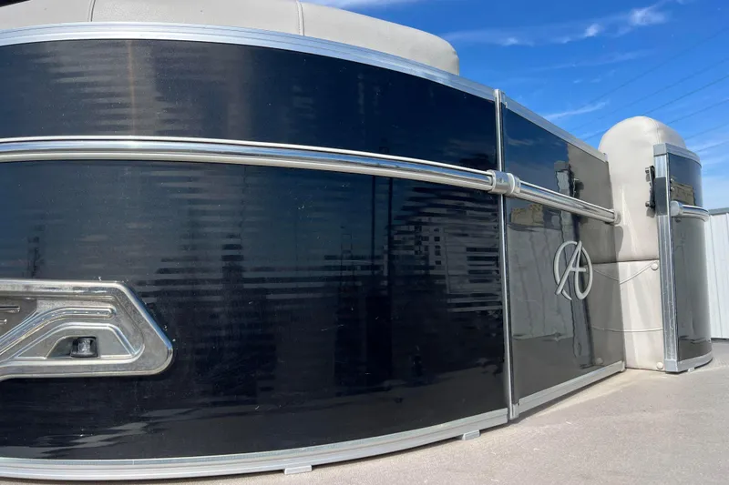 Slide: The Image of 2015 Avalon Catalina Cruise 23' pontoon boat with sleek black exterior under blue sky. - 18