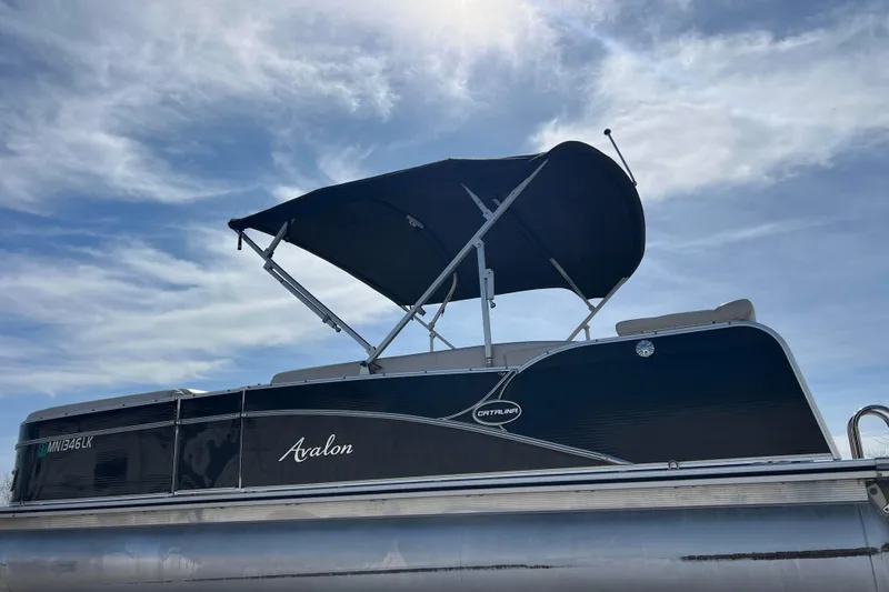 Slide: The Image of 2015 Avalon Catalina Cruise 23' pontoon boat with canopy under a blue sky. - 9