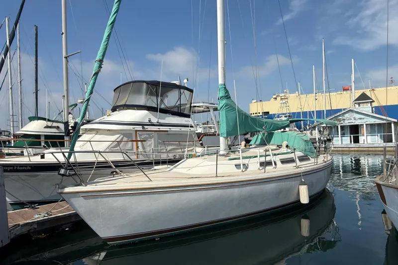 The Image of 1987 Catalina 36 sailboat docked at marina with clear sky background. - 0