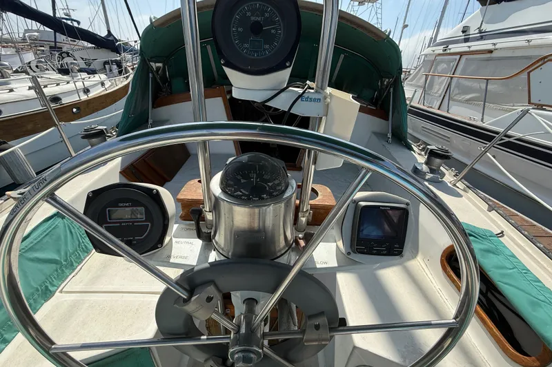 Slide: The Image of Cockpit view of a 1987 Catalina 36 sailboat with steering wheel and navigation instruments. - 13