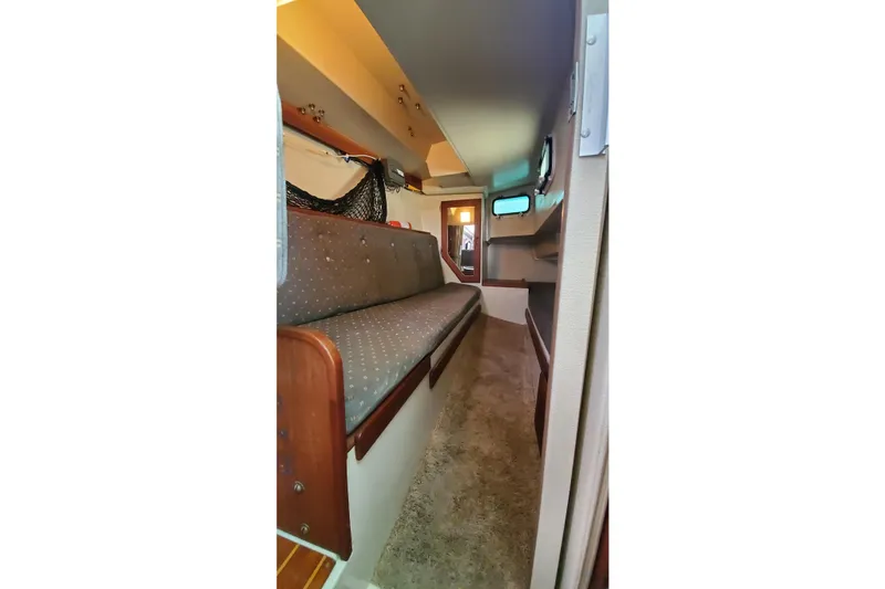 Slide: The Image of Interior cabin of a 1987 Catalina 36 sailboat with cushioned seating and storage. - 15