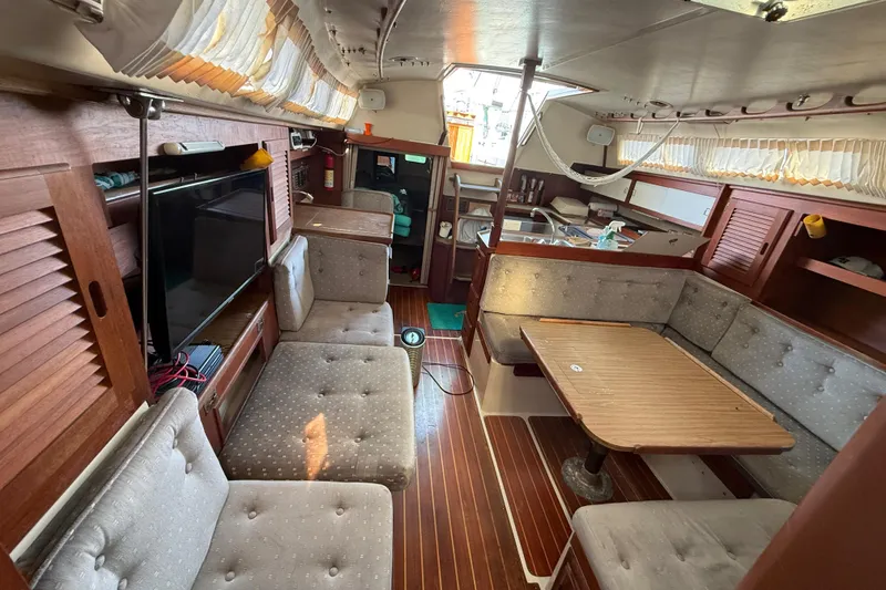 Slide: The Image of Interior of a 1987 Catalina 36 sailboat with cozy seating and wooden finishes. - 17