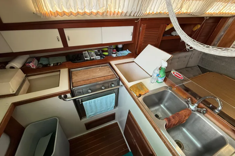 Slide: The Image of 1987 Catalina 36 yacht kitchen with stove, sink, and storage cabinets. - 18
