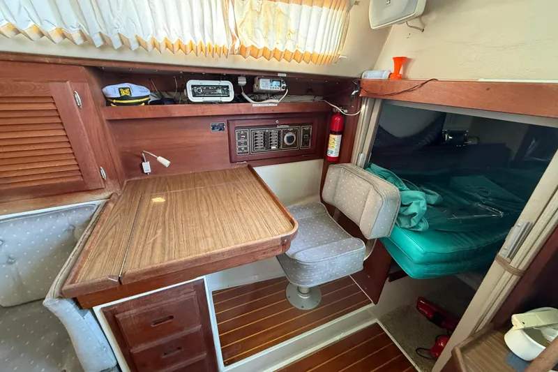 Slide: The Image of Interior of a 1987 Catalina 36 sailboat with wooden table, seating, and navigation equipment. - 20