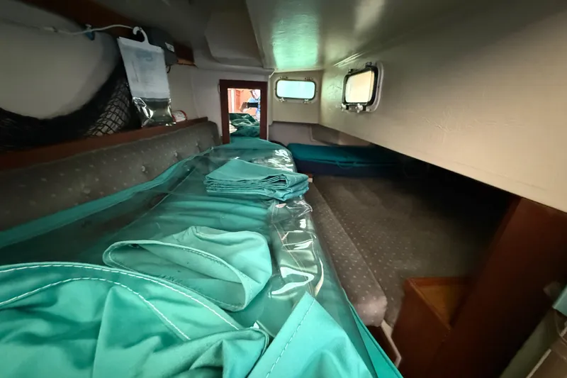 Slide: The Image of Interior cabin of a 1987 Catalina 36 sailboat with teal fabric and portholes. - 21