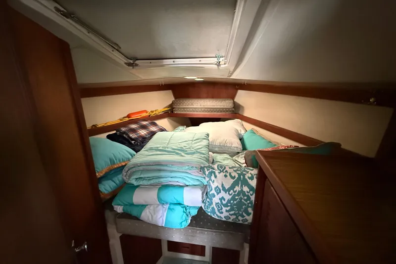 Slide: The Image of Cozy cabin interior of 1987 Catalina 36 sailboat with bedding and storage. - 24