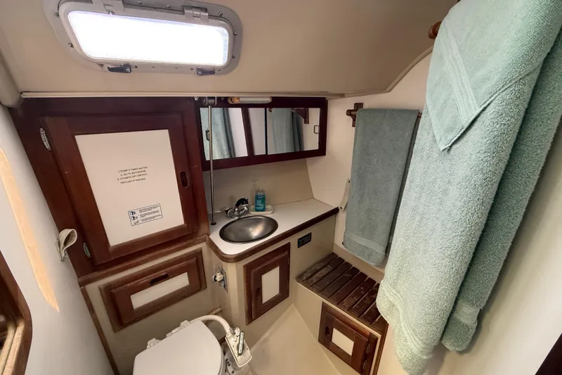 Slide: The Image of Compact bathroom in a 1987 Catalina 36 sailboat with sink, toilet, and towels. - 25