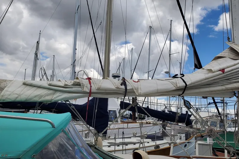Slide: The Image of 1987 Catalina 36 sailboat with sails down, docked under cloudy sky. - 7