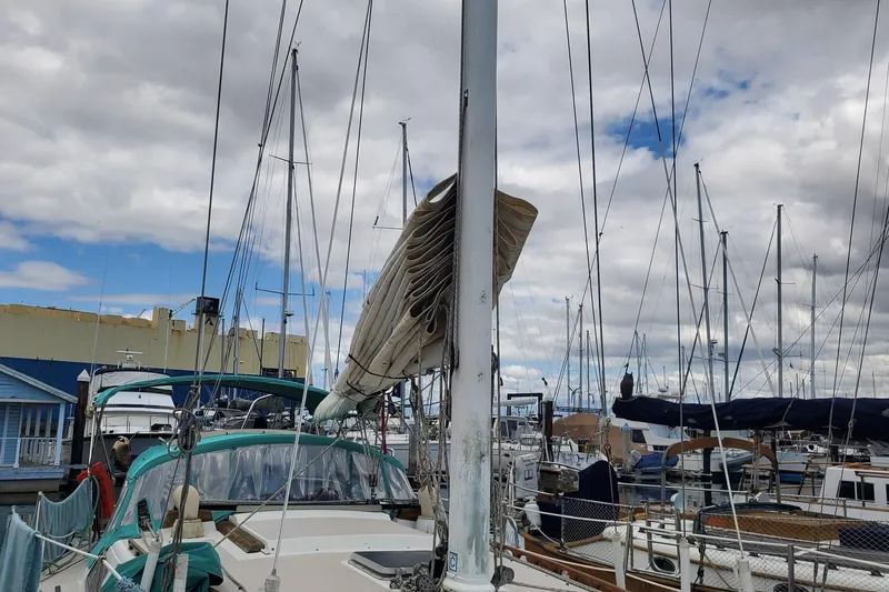 Slide: The Image of 1987 Catalina 36 sailboat docked at marina under cloudy sky. - 8