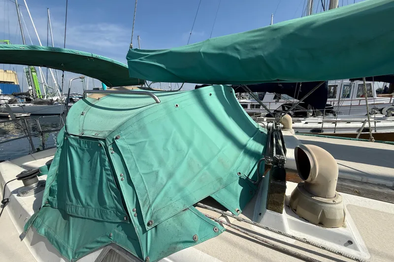 Slide: The Image of 1987 Catalina 36 sailboat with green canvas cover at marina. - 9
