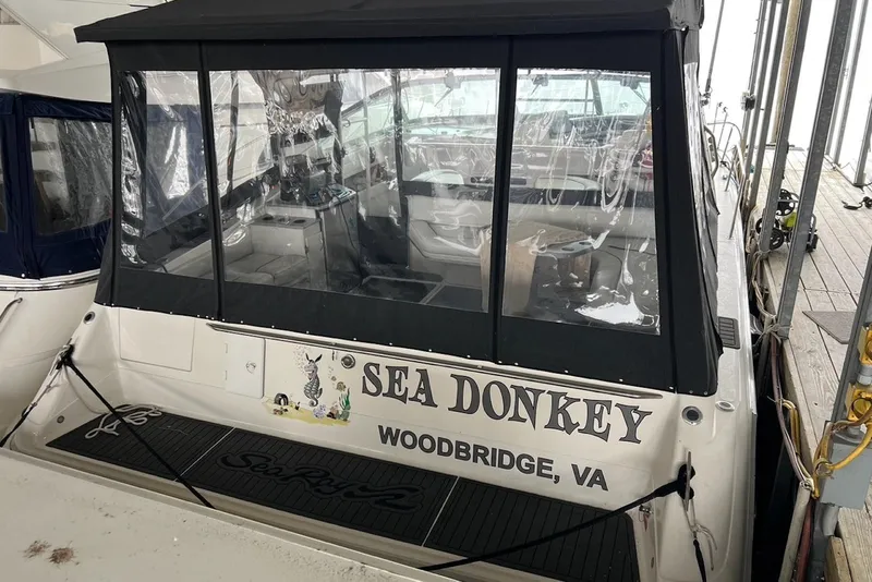 Slide: The Image of 1994 Sea Ray 440 Sundancer cockpit with clear enclosure and white seating. - 3