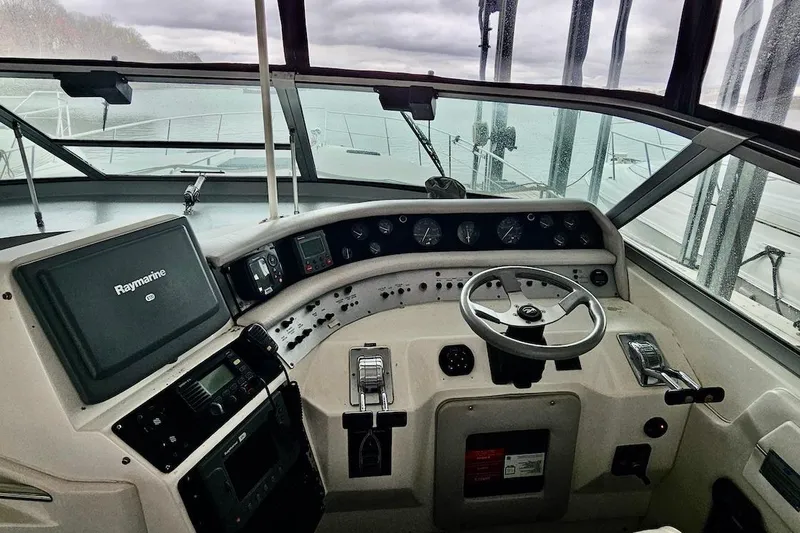 Slide: The Image of Interior of 1994 Sea Ray 440 Sundancer yacht with white leather seating and steering wheel. - 5