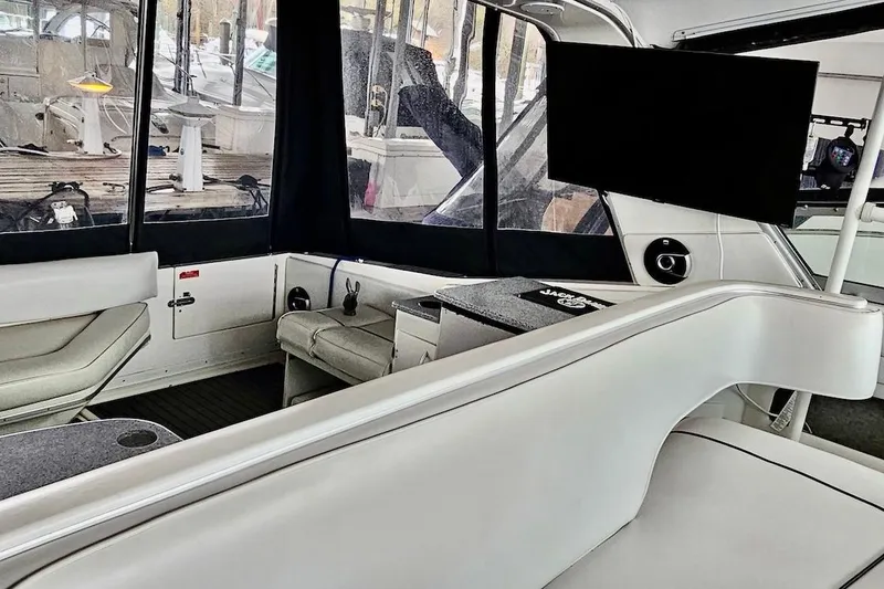 Slide: The Image of Interior of 1994 Sea Ray 440 Sundancer with white seating and a small table. - 9