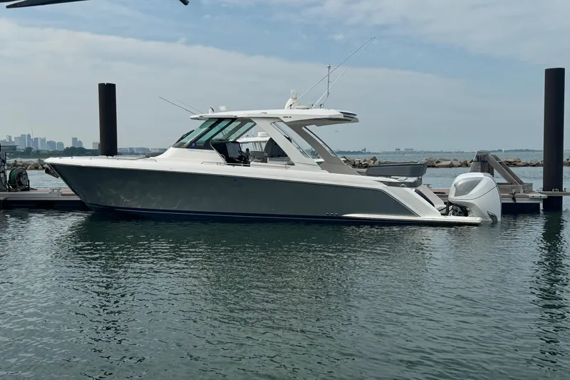 The Image of 2019 Tiara Yachts 38 LS docked in a marina, calm water, clear sky. - 0