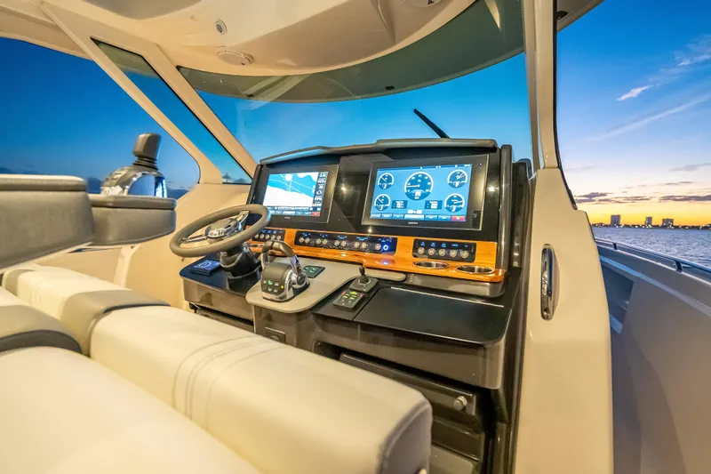 Slide: The Image of Cockpit of 2019 Tiara Yachts 38 LS at sunset, featuring advanced navigation displays. - 13