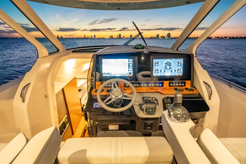 Slide: The Image of Helm of 2019 Tiara Yachts 38 LS at sunset, featuring advanced navigation controls. - 14