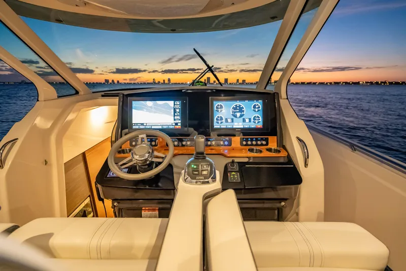 Slide: The Image of Cockpit of 2019 Tiara Yachts 38 LS at sunset, featuring advanced navigation displays. - 17