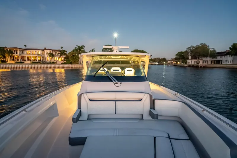 Slide: The Image of 2019 Tiara Yachts 38 LS cruising at sunset near waterfront homes. - 20