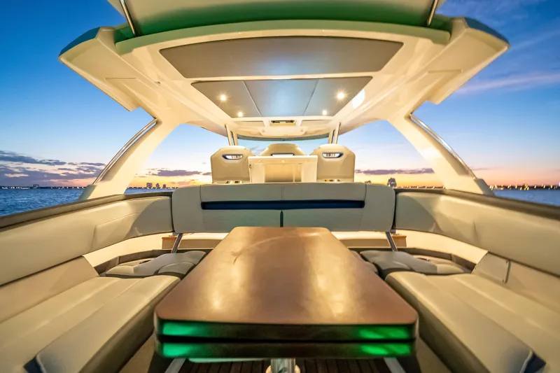 Slide: The Image of Luxurious 2019 Tiara Yachts 38 LS interior at sunset, featuring elegant seating and ambient lighting. - 29
